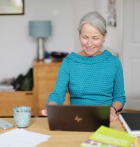 old lady in blue shirt working on laptop
