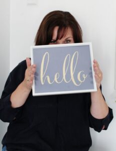 personal branding photography of a woman holding board with a message 'Hello'