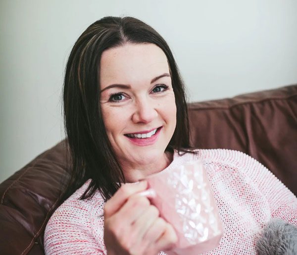 head shot photograph of lady holding a pink mug